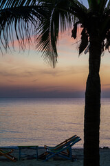 Silhouette of a chair at sunrise on a beautiful beach in Thailand.