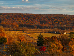 Obraz premium A rural farmland next to graveyard and mountains in autumn
