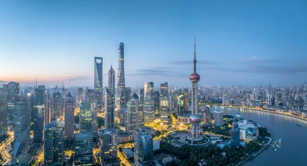 Selbstklebende Fototapeten Panoramic view of a modern city skyline with iconic tower and illuminated buildings at twilight in Shanghai © zhao dongfang