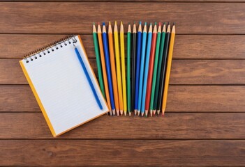 Obraz premium Colorful Pencils and Blank Notepad on Wooden Table A Vibrant Artistic Still Life