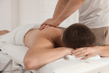 Massage therapist working with patient in clinic, closeup