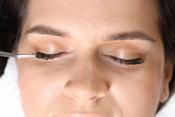 Woman undergoing lash extensions procedure in beauty salon, top view