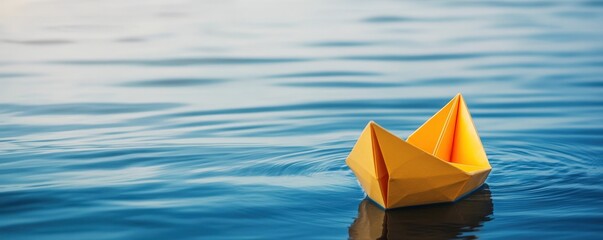 Serene Yellow Paper Boat Floating on Calm Blue Water