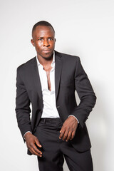 Black young businessman in a suit posing in a studio with a white background