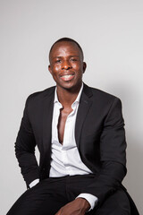 Black young businessman in a suit posing in a studio with a white background