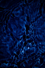 Deep Blue Water Surface with Light Reflection and Wavy Patterns