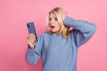 Photo of lovely pensioner lady frightened reaction hold device dressed stylish blue knitted garment...