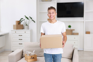 Fototapeta premium Happy man with moving box in new apartment. Housewarming party