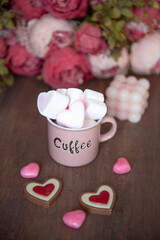 Valentine hot chocolate or coffee, Two red cups with hot chocolate or latte drink, with whipped cream ans sugar heart sprinkles, with roses bouquet ad gift box