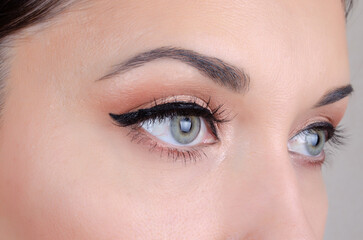 Elegant close-up of green female eyes with eyeliner and natural makeup