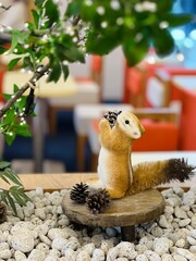 Squirrel holding a pine cone and looking at a tree