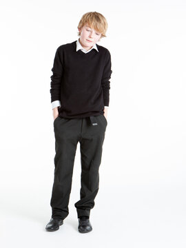 Early Teenage Students: Looking Down. An early teenage boy in school uniform and an introspective mood.