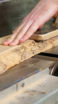 Sanding a Wooden Board on a Sanding Machine in a Workshop