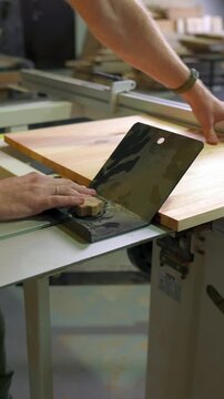 Carpenter Clamping a Workpiece for Sawing on a Woodworking Machine
