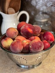 Freshly Picked Peaches in a Stainless Steel Colander after being Washed, on Kitchen Countertop.