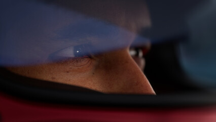 Close-up of a focused pilot driver in a red racing car, preparing for a race
