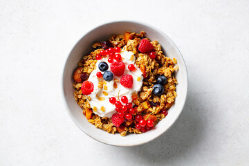 Healthy breakfast. Granola, muesli with yogurt and fresh berries. Grey background. Close up. Top view.