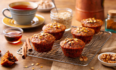 Healthy vegan carrot and oats muffins with cup of tea. Wooden background. Close up. Top view.