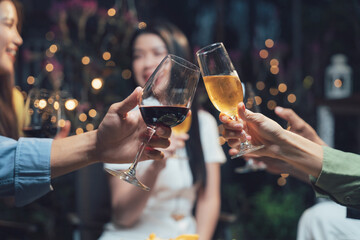 Cheers to Friendship: A toast to togetherness! Close-up of hands raising wine glasses, celebrating friendship and good times with a bokeh background of warm lighting and happy faces.