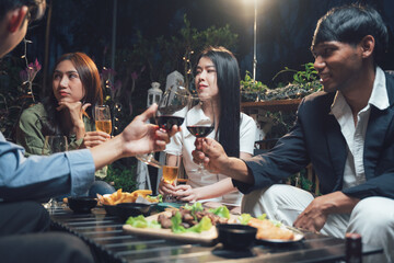 Nighttime Gathering:  Friends raise their glasses in a toast, enjoying a relaxed evening together, a moment of connection and laughter.  
