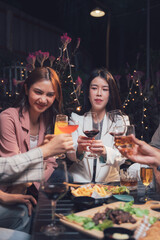 Cheers to Friendship: A group of friends raise their glasses in a toast, surrounded by the warm ambiance of a cozy outdoor setting.