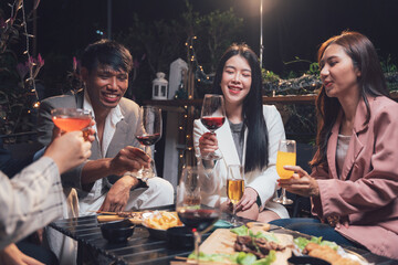 Nighttime Gathering: Friends Toast to Good Times: A group of friends raise their glasses in a warm and inviting nighttime setting, capturing the essence of connection, laughter, and shared moments.
