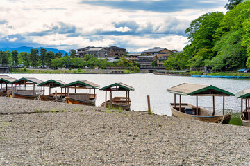Scenic landscape from Arashiyama with traditional japanese boats at the dock on Katsura river, in Kyoto.