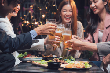 Cheers to Success: Friends toasting beers at a lively restaurant celebration.  The image captures a moment of shared joy and camaraderie. 