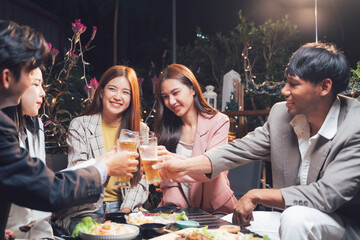 Cheers to Friendship: A group of friends raise their glasses in a toast, their smiles illuminating the night as they share laughter and camaraderie at a lively gathering.  