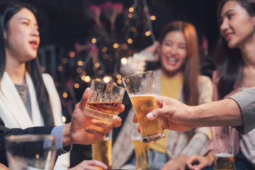 Cheers to Friendship: A toast to camaraderie and good times.  Close-up shot of friends raising glasses in a lively bar setting, capturing the warmth and joy of shared moments. 