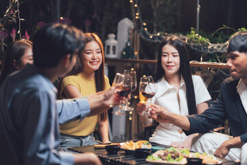 Nighttime Cheers: A group of friends toast each other with glasses of red wine, basking in the warmth of a shared moment of connection and joy. The intimate scene captures the essence of friendship.