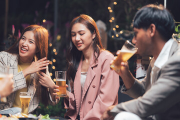 Nightlife Laughter: Friends Enjoying Drinks and Conversation at a Lively Outdoor Gathering 
