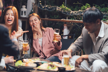 Night Out Laughter: Friends enjoying drinks and appetizers at a lively outdoor restaurant, sharing laughter and good times.  