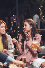 Night Out Laughter: A group of friends enjoys a lively conversation over drinks at a dimly lit outdoor bar.  The image captures the warmth and conviviality of a social gathering.