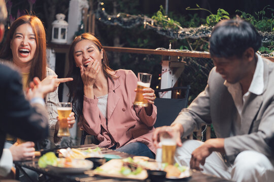 Night Out Laughter: Friends enjoying drinks and appetizers at a lively outdoor restaurant, sharing laughter and good times.  