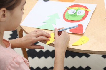 Girl drawing card at table indoors, closeup. Art and craft