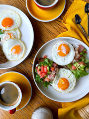 Breakfast with eggs, bruschetta and coffee on a wooden table