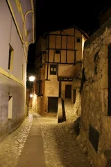 Poster Narrow street with beautiful houses at night in Albarracin town