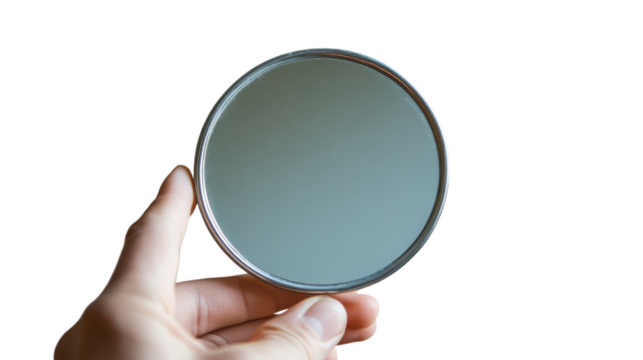 A hand holding a small round mirror reflecting soft light against a minimalistic background
