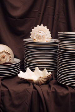 Still life composition with stacked ceramic plates,  seashells
