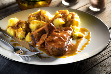 Braised pork neck in own sauce served with boiled potatoes.