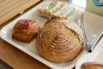 パン屋でトレイに乗せたパン、サンドイッチ、サンドウィッチ、クロワッサン