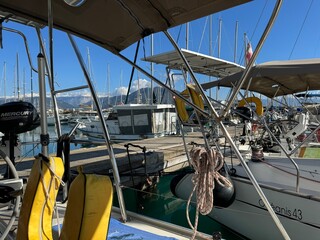 Sailboats lined in the marina with mountains in the background in daylight