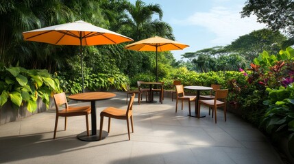 Relaxing Outdoor Cafe Scene with Orange Umbrellas and Wooden Furniture Surrounded by Lush Greenery and Tropical Foliage in a Bright Sunny Atmosphere