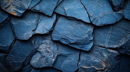 Close-up texture of dark blue slate rocks, showcasing rough cracked layers. Ideal for backgrounds, geology presentations, or design projects requiring a natural, earthy tone.