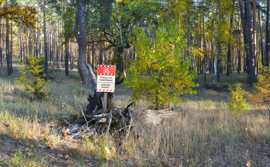 Warning of a mined forest. Sign at the entrance to the forest warning of a mined area and danger to life. War in Ukraine.
