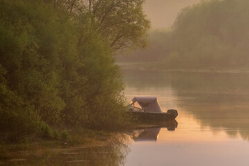fishing boat on the foggy lake