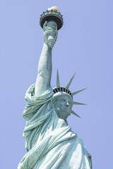 Closeup of the Statue of Liberty on the Liberty Island in New York against a clear blue sky.