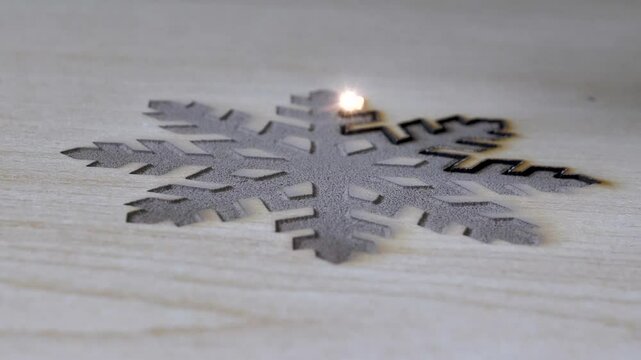 Traditional motifs engraved on wood with CNC laser machine. Image of computer-controlled cnc laser machine for engraving motifs on wood.