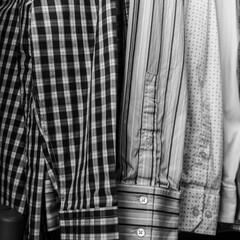 macro close-up of mens long sleeve dress business work attire shirts lined up in a row closet backdrop